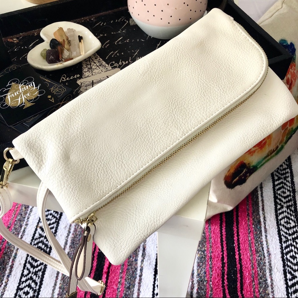 White, fold-over clutch with zipper and strap.